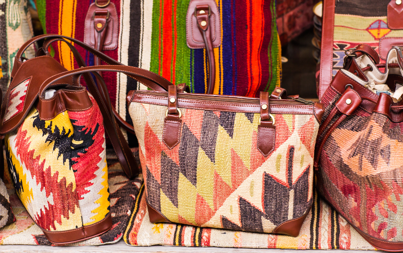 Colorful tribal-patterned handbags on display, showcasing unique designs ideal for Etsy marketing strategies.